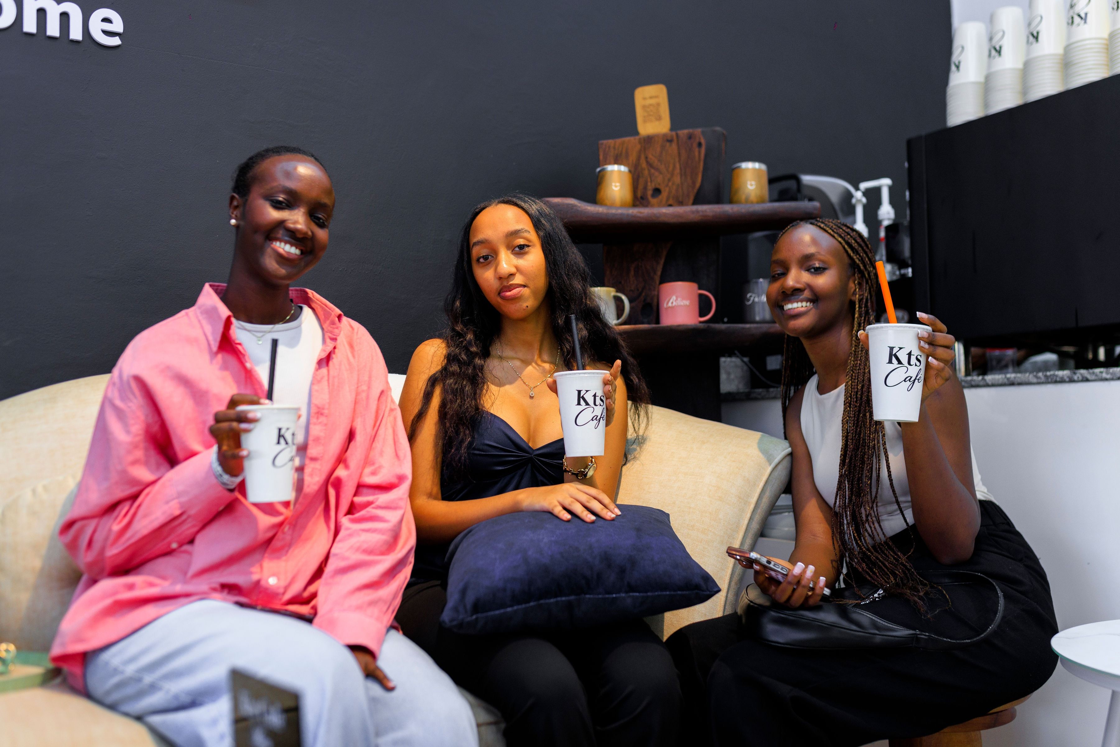 Friends laughing over coffee together on the cosy lounge couch at KTS Café